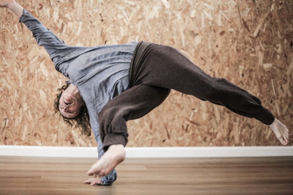 אשה נשענת על הזרוע ושולחת רגליים באויר