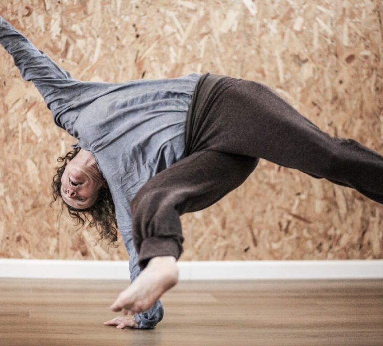 אשה נשענת על הזרוע ושולחת רגליים באויר